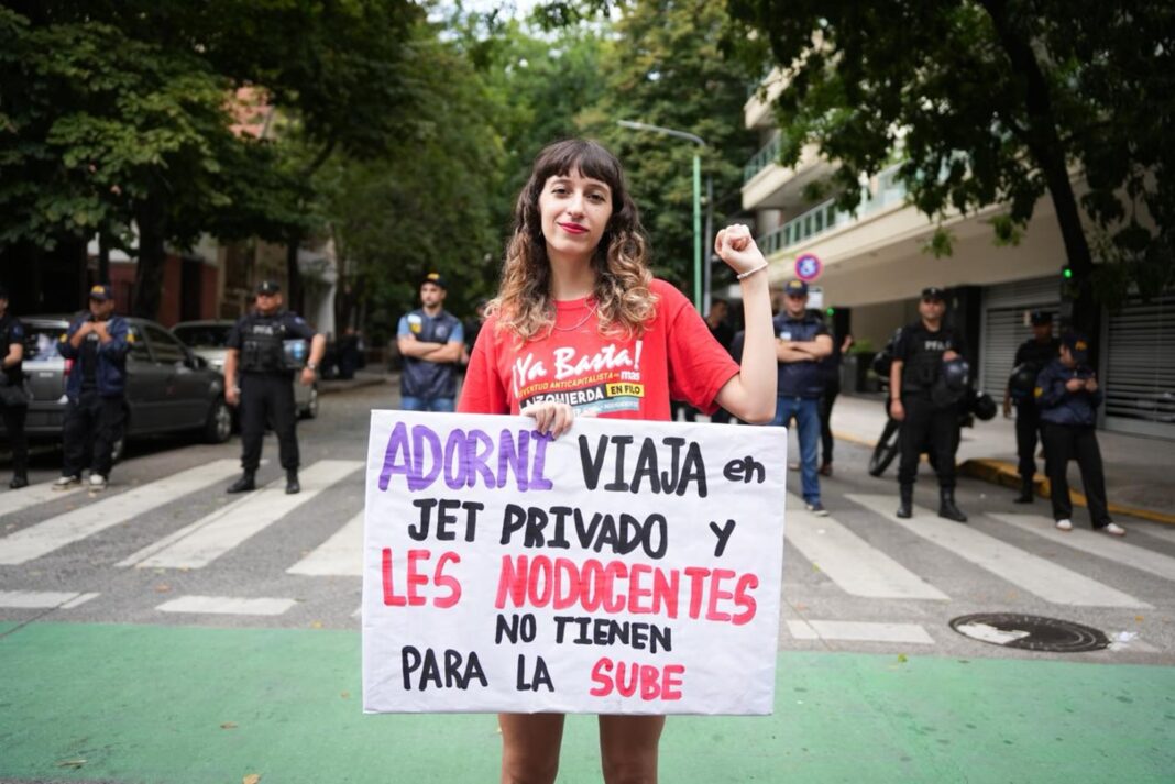 Estudiantes y manifestantes realizando clases públicas en una vereda de Caballito, con presencia policial al fondo.