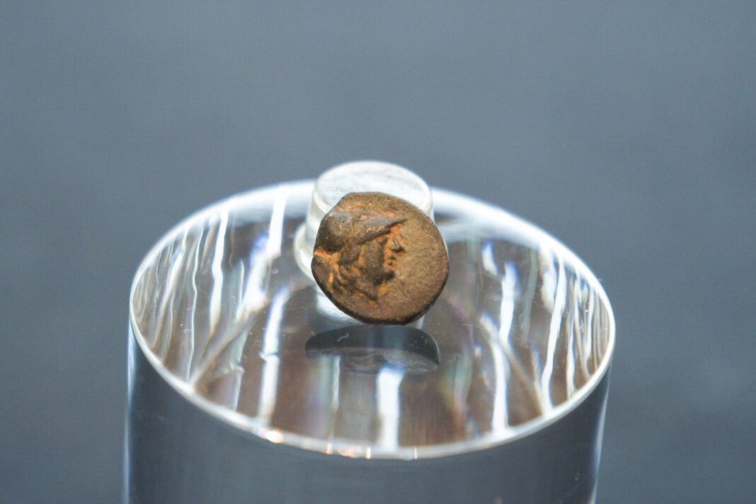 Moneda griega de bronce con la cabeza de Atenea en el anverso