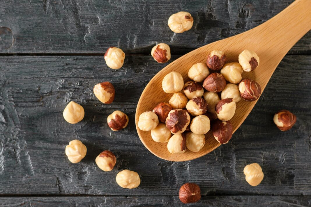 Puñado de avellanas naturales sobre una superficie de madera