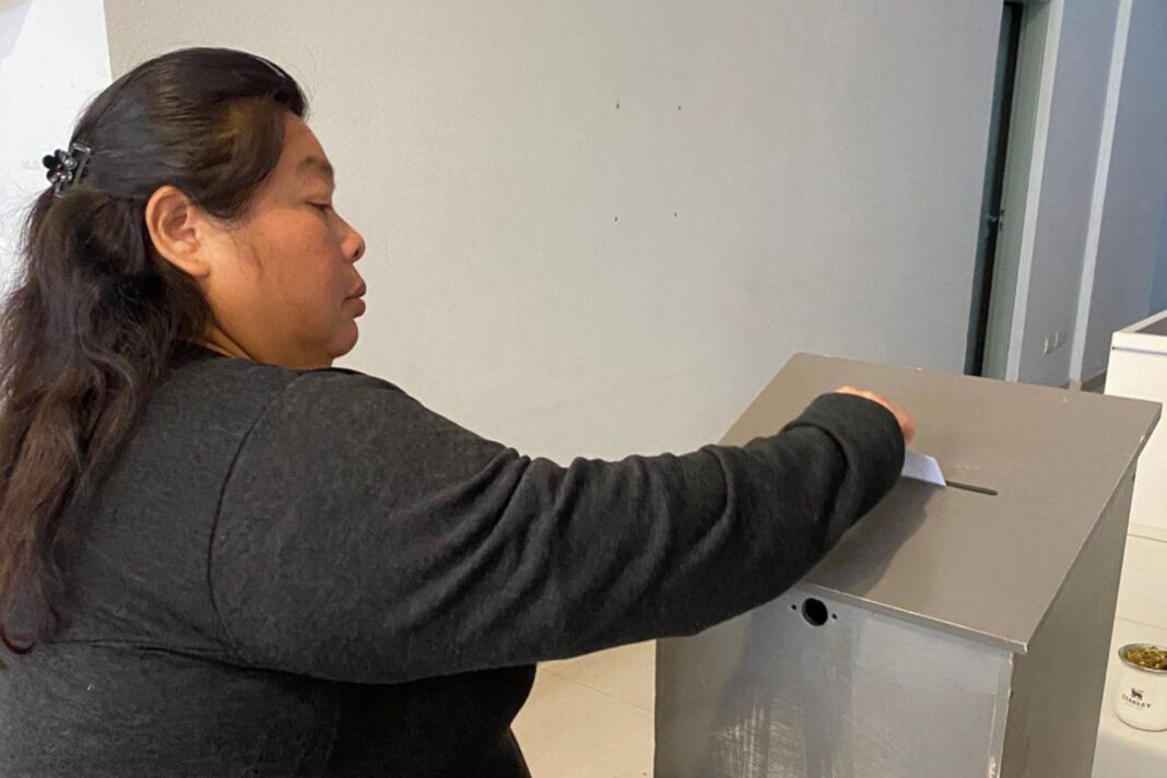 Persona consultando en un dispositivo digital el lugar de votación para las elecciones de Perú.