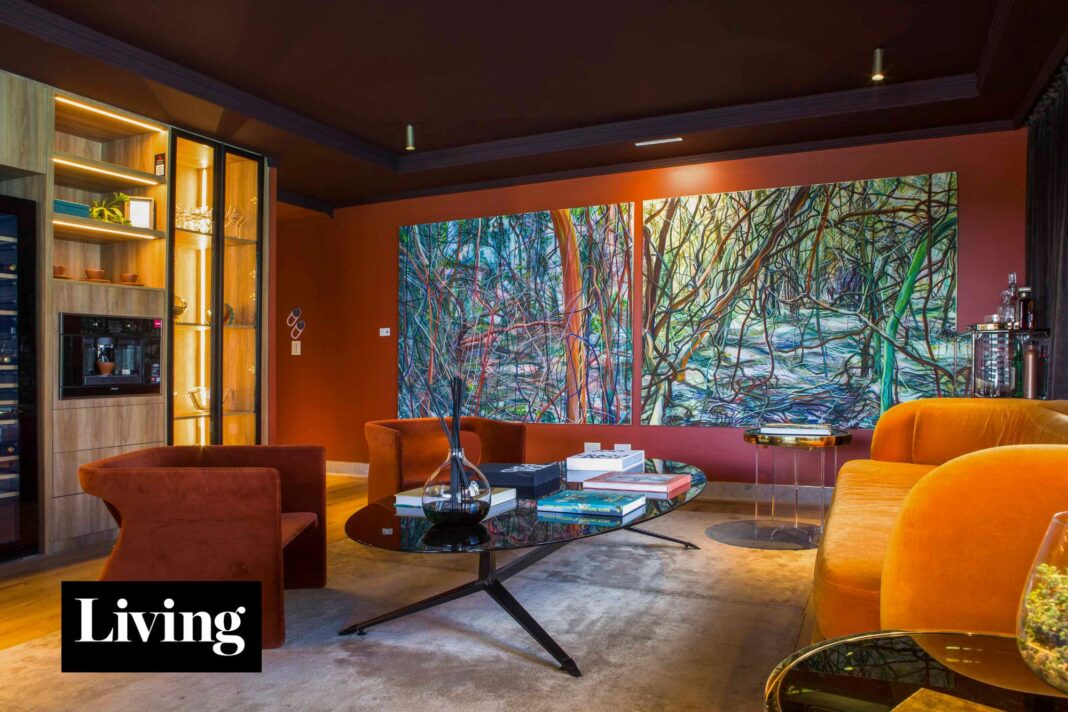 Vista del living y la isla de mármol en el departamento diseñado por Gaby López Monzón, con tonos tierra y obras de arte.