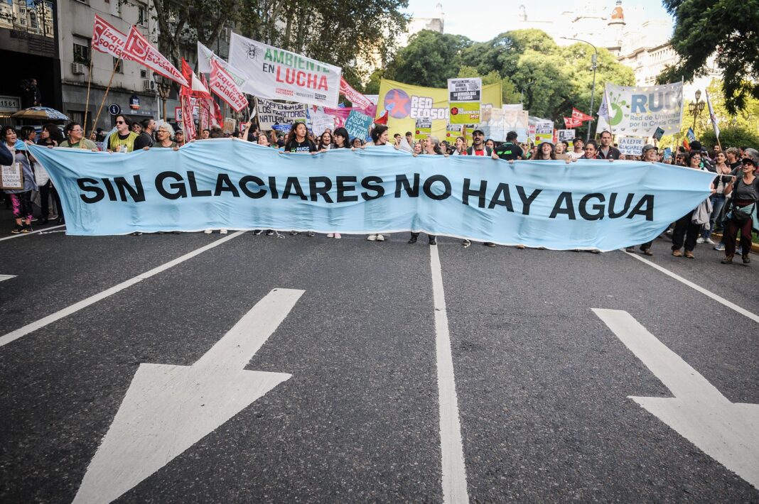 Personas con antorchas en una marcha nocturna en defensa de los glaciares y las universidades