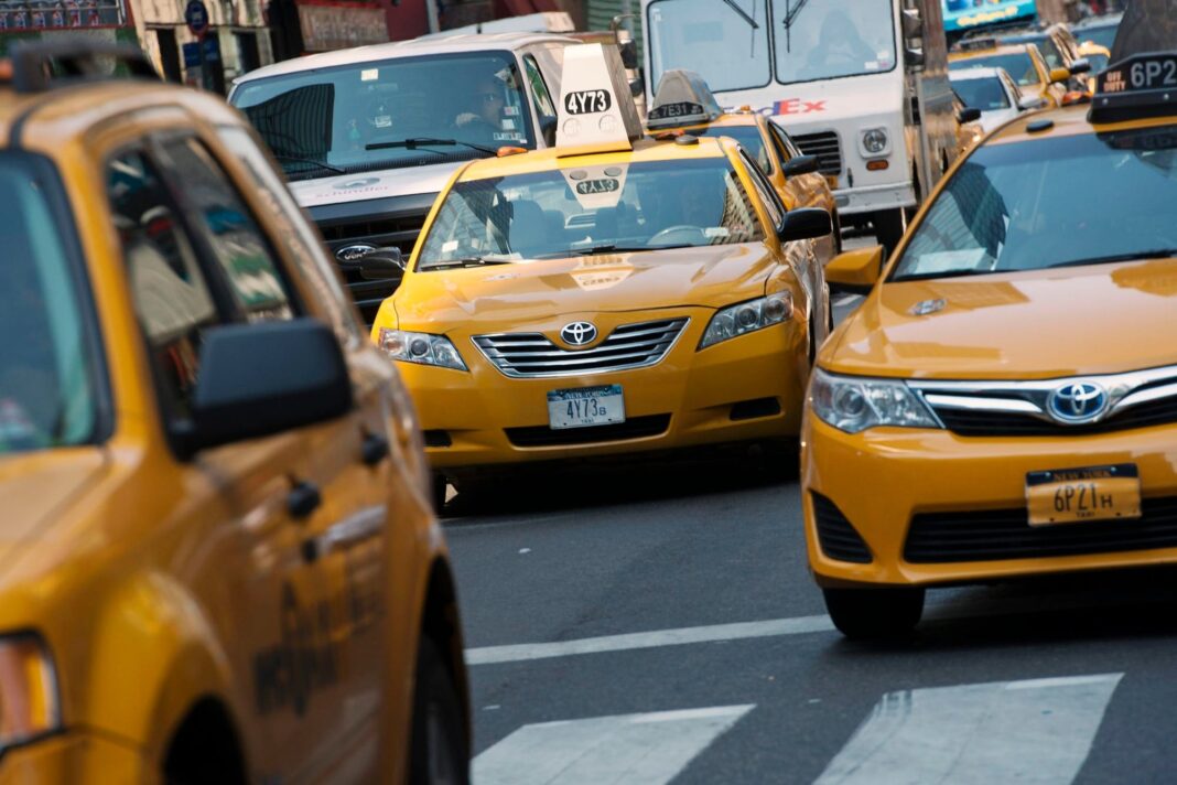Taxista latino conduciendo un taxi amarillo por las calles de Nueva York