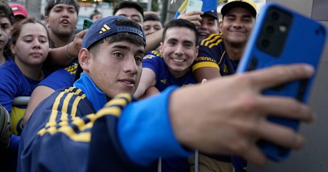 Escudos de Universidad Católica de Chile y Boca Juniors con el trofeo de la Copa Libertadores de fondo.