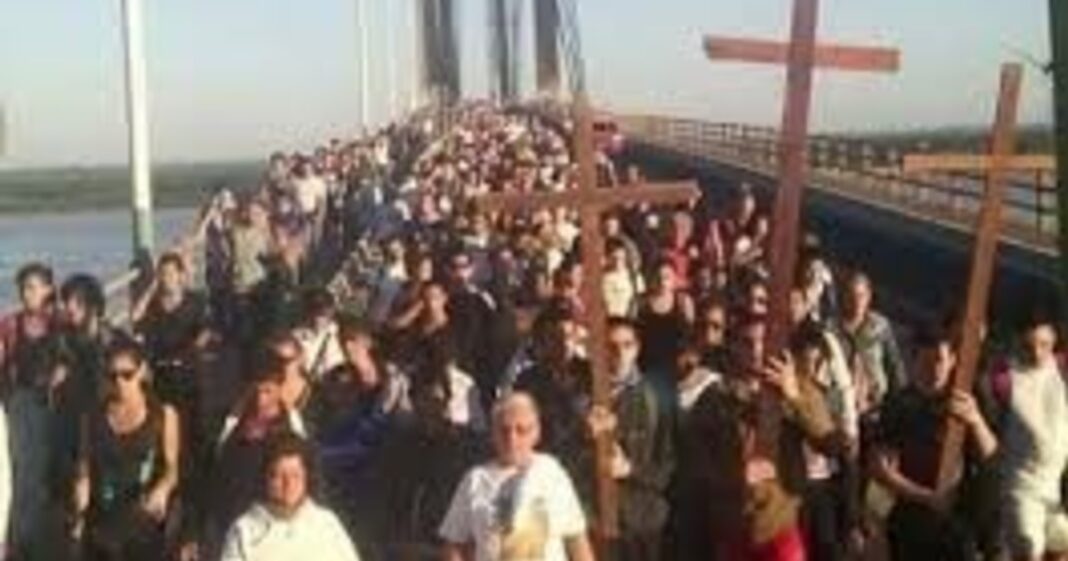 Personas participando en un Vía Crucis nocturno con antorchas en un cerro, representativo de las tradiciones argentinas en Semana Santa.