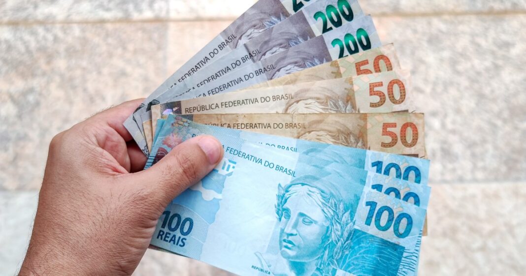 Billetes de reales brasileños y monedas, con fondo de calculadora