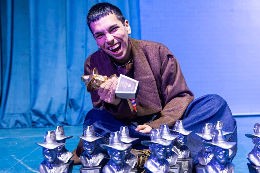 Milo J sosteniendo estatuillas de los Premios Gardel en el Teatro Coliseo