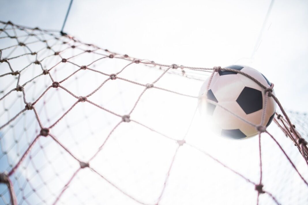 Jugador de fútbol pateando un penal en un estadio