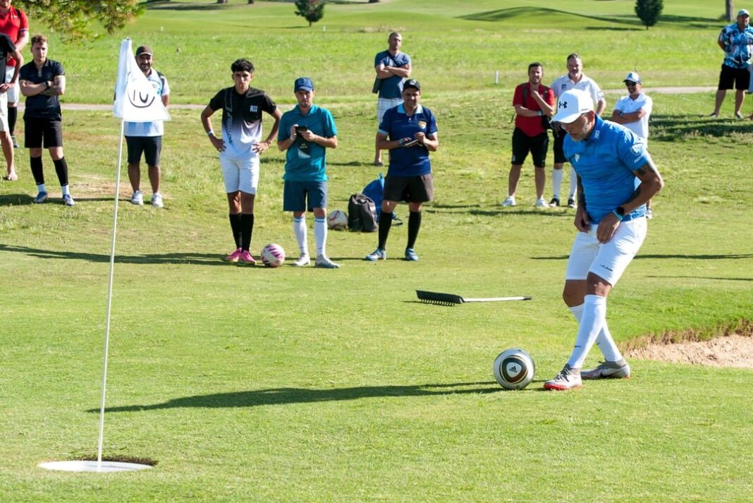 Jugadores de FootGolf en un campo verde con hoyos y banderas
